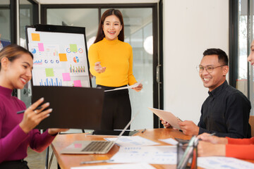 Group of Asian businessmen are sitting in a meeting, talking, exchanging knowledge. Presentation about office work
