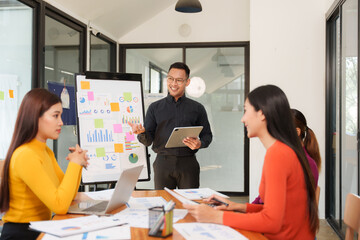 Group of Asian businessmen are sitting in a meeting, talking, exchanging knowledge. Presentation about office work