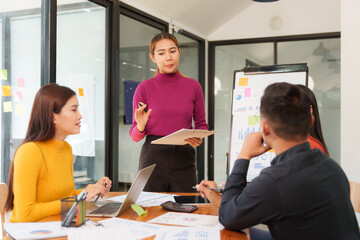 Group of Asian businessmen are sitting in a meeting, talking, exchanging knowledge. Presentation about office work