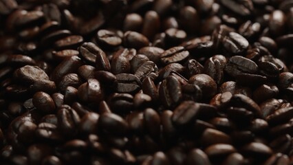 Macro shot of super slow motion shot of fresh coffee bean placed with black background. Close up of piles of aromatic roasted coffee seed surrounded. Macrography. Beans scattering around. Comestible.