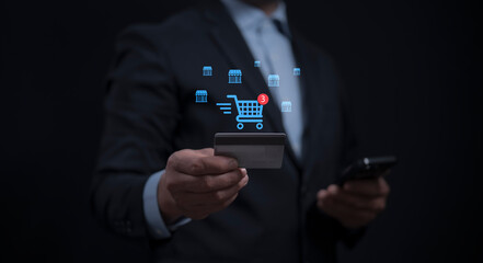 Businessman holding credit card with online shopping digital cart for shopping payment online with application.Intelligent E-commerce, internet banking payment, financial technology. lifestyle