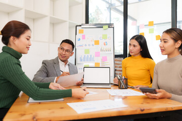 Group of Asian businessmen are sitting in a meeting, talking, exchanging knowledge. Presentation about office work