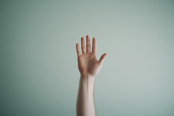 Raised hand against a soft green background