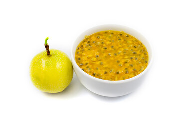 Yellow passion fruit and passion fruit pulp in a white cup on a white background.