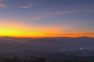 Obraz premium Heaven at early morning with copy space. Sunset with mountains, sunrise backdrop.Predawn clear sky with orange horizon and blue atmosphere. Smooth orange blue gradient of dawn sky.