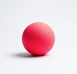 Vibrant red rubber ball on a plain background
