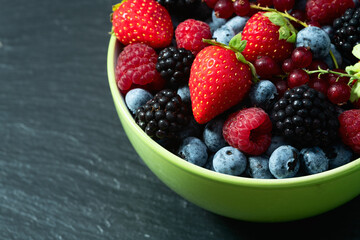 Mix of ripe colorful berries in bowl photography . Blueberry , strawberry , raspberry , blackberry and red currant . Top view