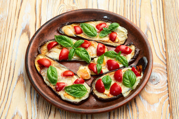 Italian mini pizza . Aubergine (eggplant ) with mozzarella cheese and basil . On rustic background