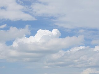 Obraz premium Fluffy white clouds floating in a clear blue sky, puffy, overcast