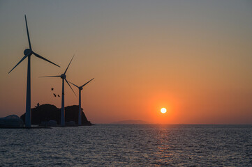 on the beach with a wind turbine and an island in the background taken at the tando island port of Korea.