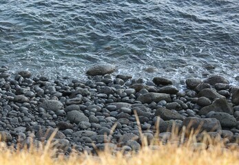 A landscape photograph of detail at a black pebble beach in Iceland