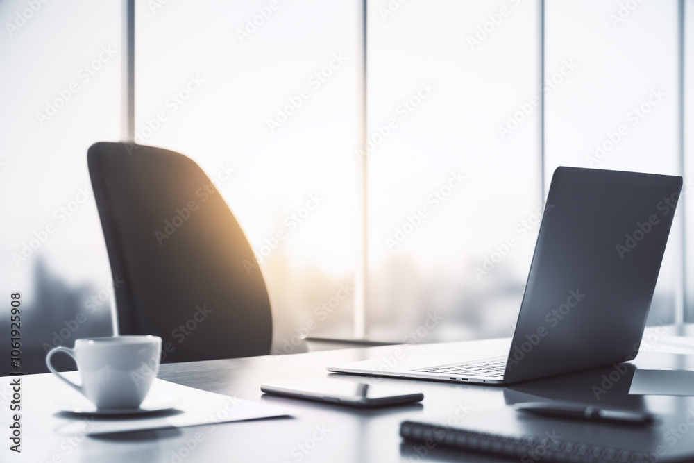Aufkleber perspective view on sunlit office workspace with modern laptop, tea cup and smartphone on dark table
