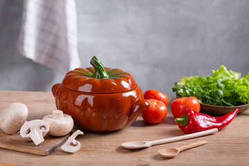 Fresh vegetables, herbs and cereals lie on a wooden countertop in the kitchen