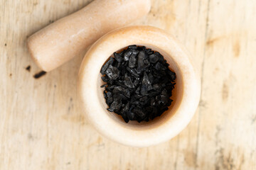 Black powder in a marble mortar close-up
