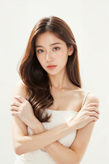 A woman with long brown hair and a white tank top is posing for a picture