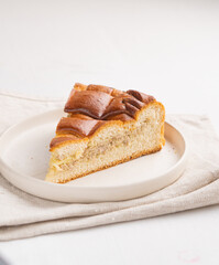 A piece of yeast pie with meat filling on a light background