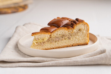A piece of yeast pie with meat filling on a light background