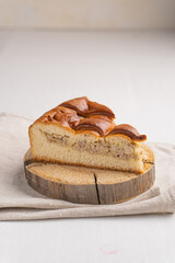 A piece of yeast pie with meat filling on a light background