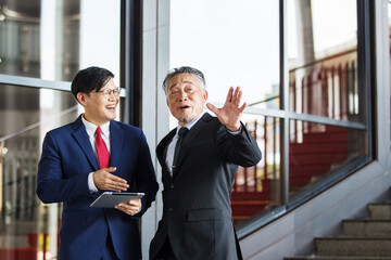 Two Asian businesspeople having a business discussion in the office building.