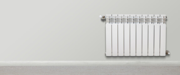 White heater hangs on a gray wall. Central heating concept. Banner