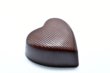 Chocolate candy with heart-shaped filling on white background.