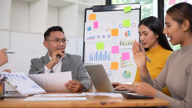 Collaborative Business Meeting Professionals Engage in Data Analysis, Teamwork, and Insightful Discussions with Charts, Graphs, and Laptops.