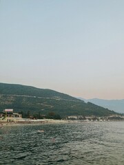 Fototapeta premium Evening tourist view of the Adriatic sea with mountains and the city of Budva in Montenegro