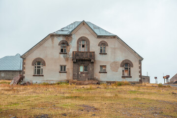 Abandoned rural house with peeling paint and broken windows