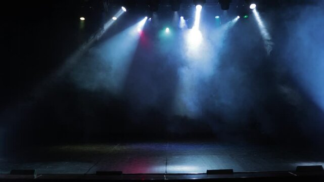 An empty stage of the theater, lit by spotlights and smoke before the performance