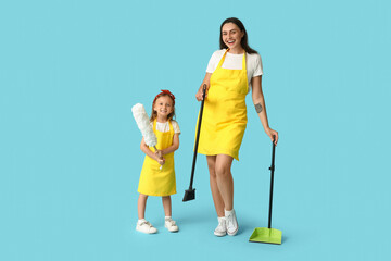 Happy mother and her daughter with different cleaning supplies on blue background