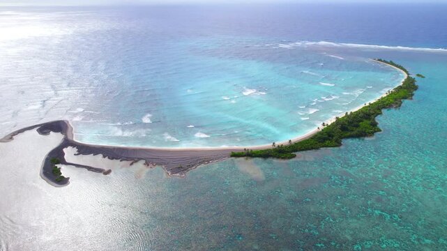 An aerial shot of a crescent shaped tropical island in the Palmyra Atoll