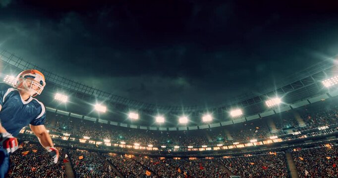 This video captures a dramatic moment in an American football game as a player in a blue jersey dives mid-air to catch the ball. The bright stadium lights and cheering crowd amplify the intensity and 
