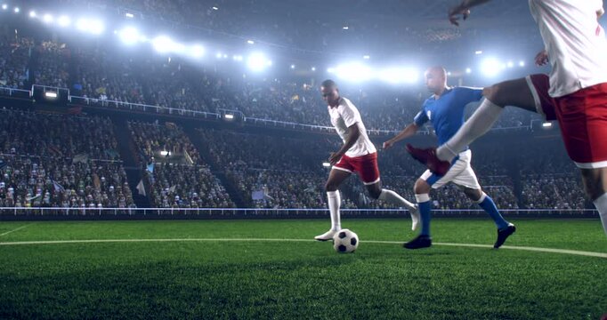 Football player is dribbling the ball down the field and kicks the ball towards the goal while other players trying to interfere. Professional stadium with animated crowd.