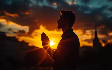 Powerful silhouette of a man praying with clasped hands against a radiant sunset, symbolizing the authority of the kingdom of God