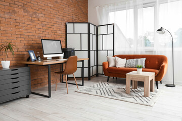 Interior of office with sofa and portable power station on desk