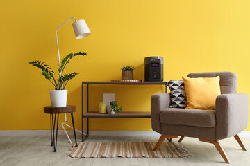 Interior of living room with armchair and portable power station on shelf