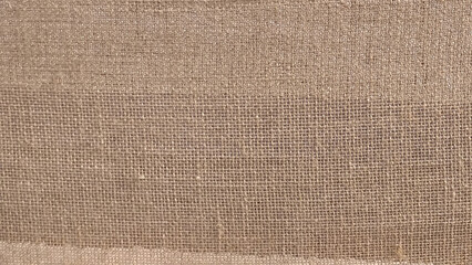 Hessian sackcloth woven fabric texture background in beige cream brown color. 