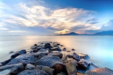 Obraz premium Serene Sunrise Over Rocky Seashore Landscape