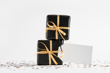 Black gift boxes and confetti on white background
