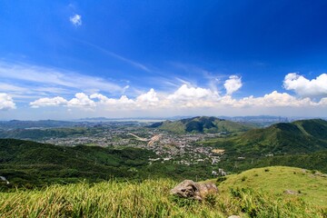 A Panoramic View of Rolling Hills, Lush Green Fields, and a Clear Blue Sky