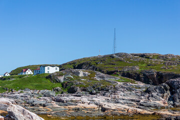 Fototapeta premium Coastal Landscape with Houses on Rocky Cliffs Under Blue Sky