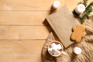 Composition with book, warm clothes, cup of cocoa drink and burning candles on wooden background