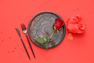 Beautiful table setting with red rose, paper heart and gift box on color background. Valentine's Day celebration
