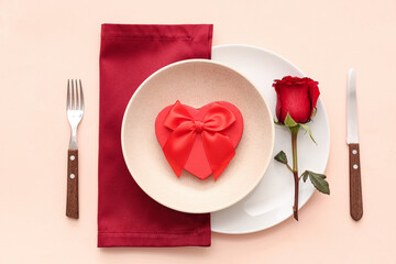 Beautiful table setting with red rose and gift box on beige background. Valentine's Day celebration