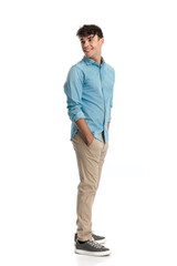 Fototapeta premium side view of happy casual guy looking behind and standing in line