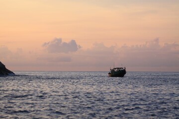 Solitary Fishing Boat at Sunset on Calm Ocean