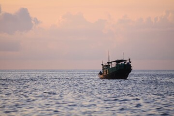 Solitary Fishing Boat at Sunset on Calm Ocean