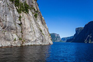 Fototapeta premium Stunning Rocky Cliffs Overlooking a Serene Blue Fjord