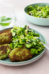 Zucchini and broccoli pancakes served with a mixed salad of cucumbers, young peas, and radishes. This healthy vegetarian dish is both delicious and nutritious