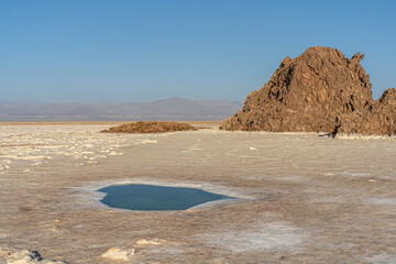 Plain of salt with salty pond and salt rocks in the Danakil Depression in Ethiopia